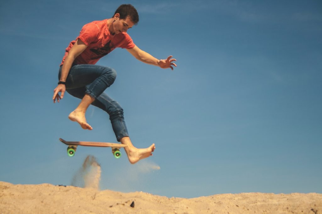 Muž skateboarding na písku.