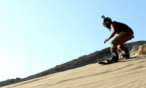 Sandboarder with helmet, goggles and go pro camera