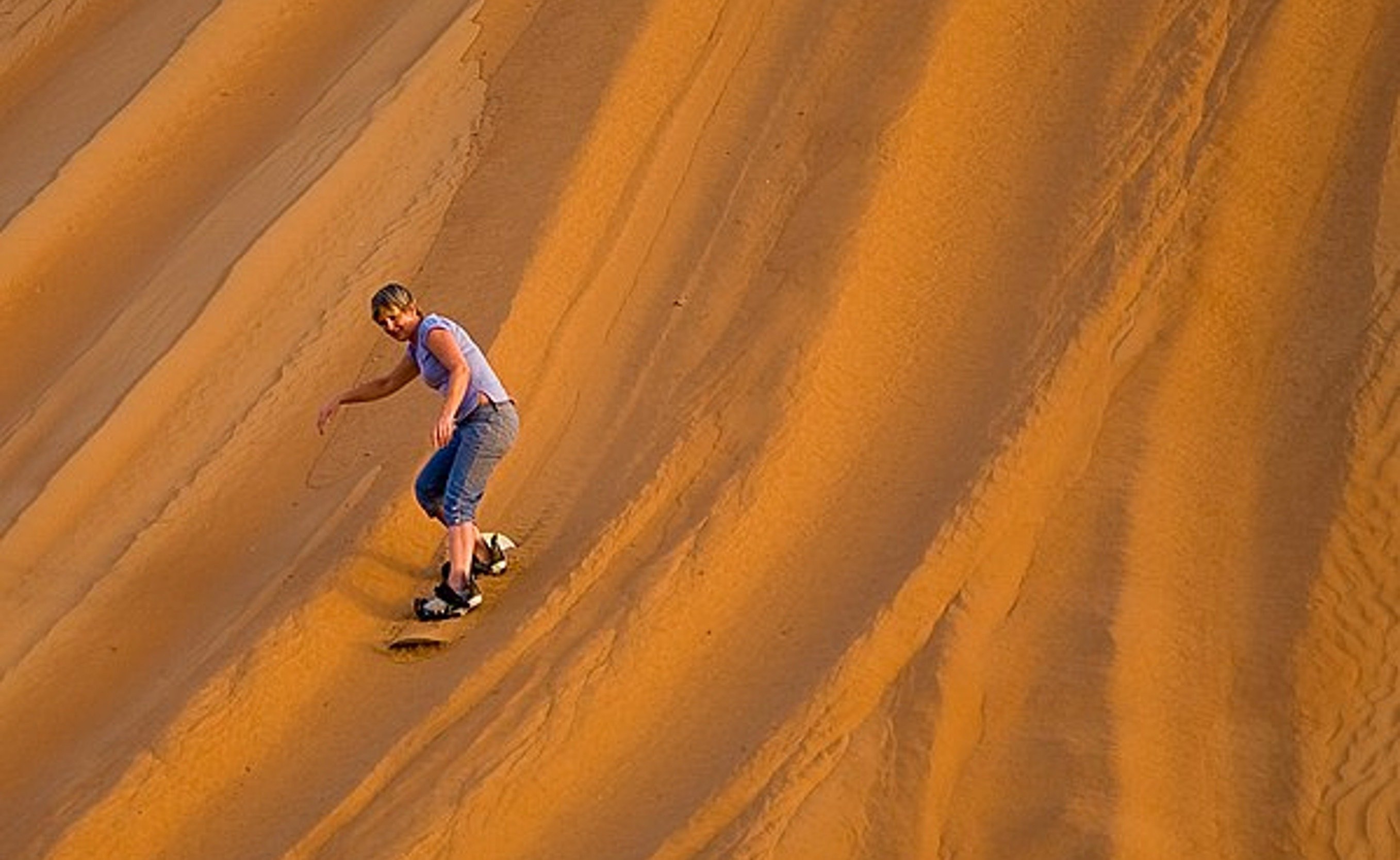 Sandboarden bij Wahiba Sands, Oman.