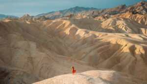 Женщина, стоящая на скале с видом на обширный пустынный ландшафт