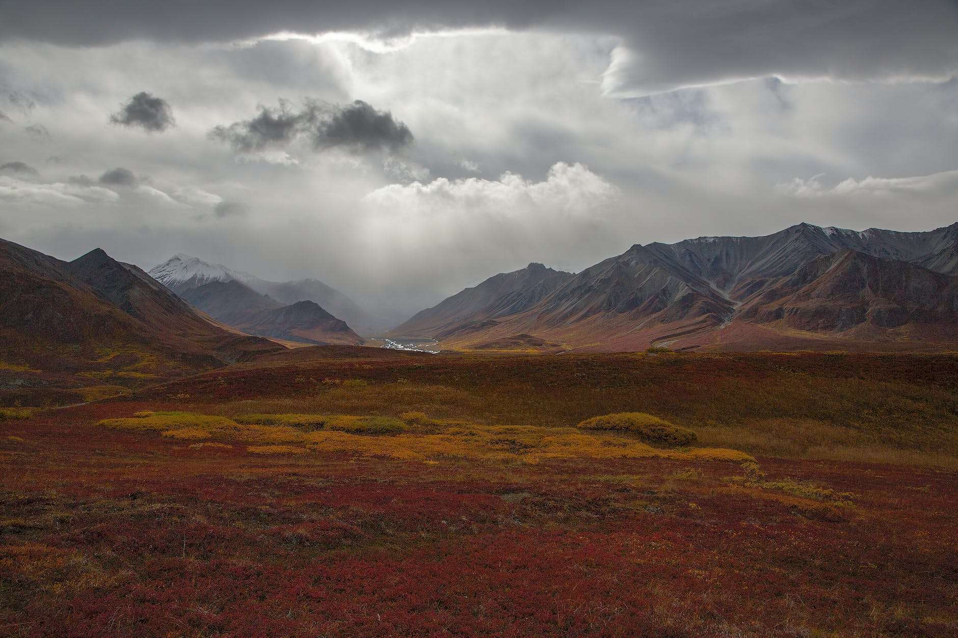 sunbeams shining on a scenic tundra and mountain landscape