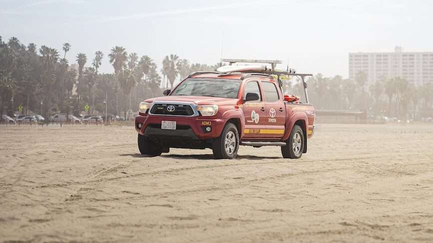 red pickup truck on brown sand. Los Angeles, USA