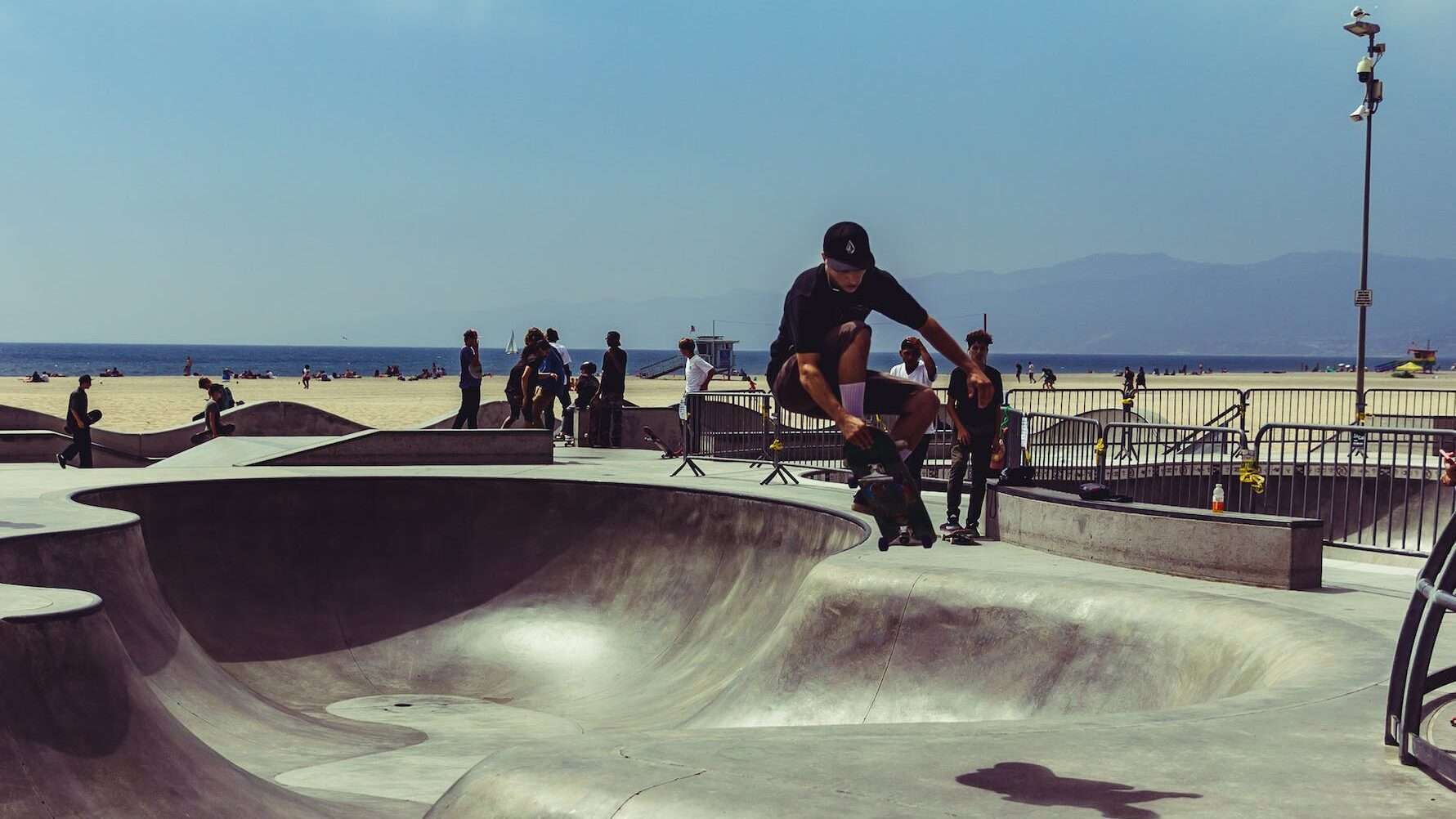 bărbat îmbrăcat în cămașă neagră face skateboarding