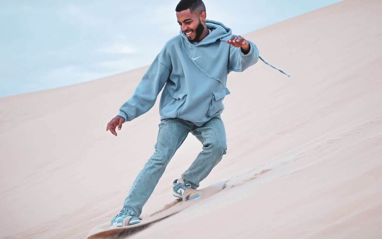 a man snowboarding on the sand