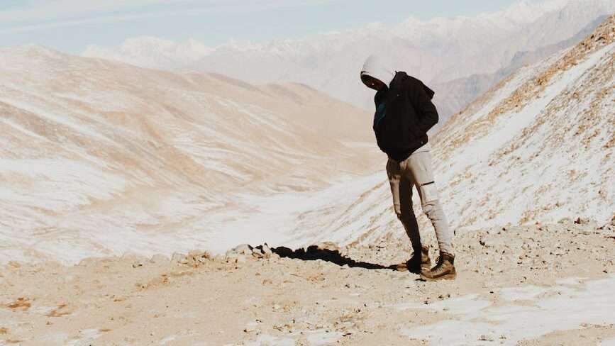 a man hiking in mountains on the desert