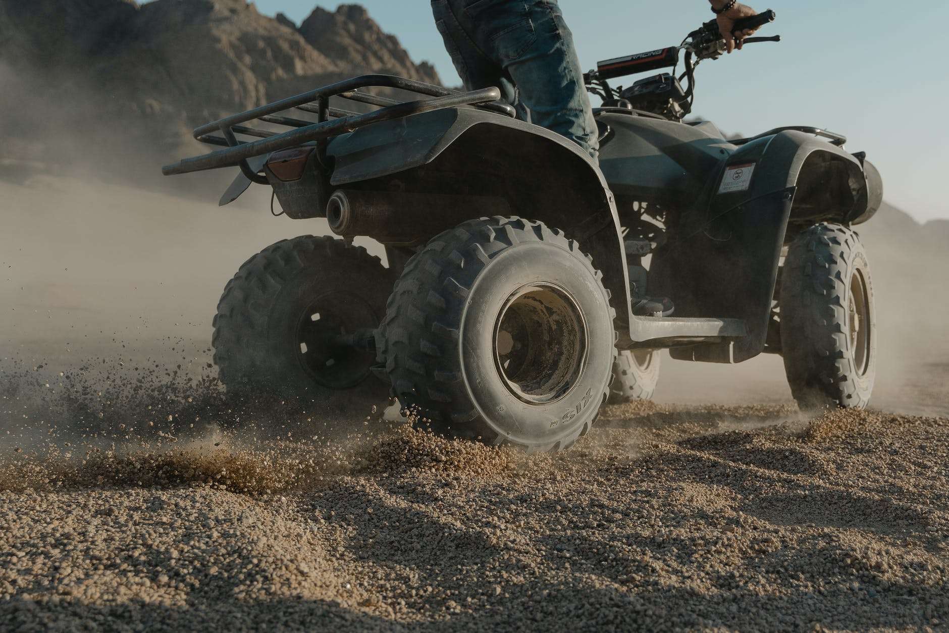 person doing atv drift on brown sand