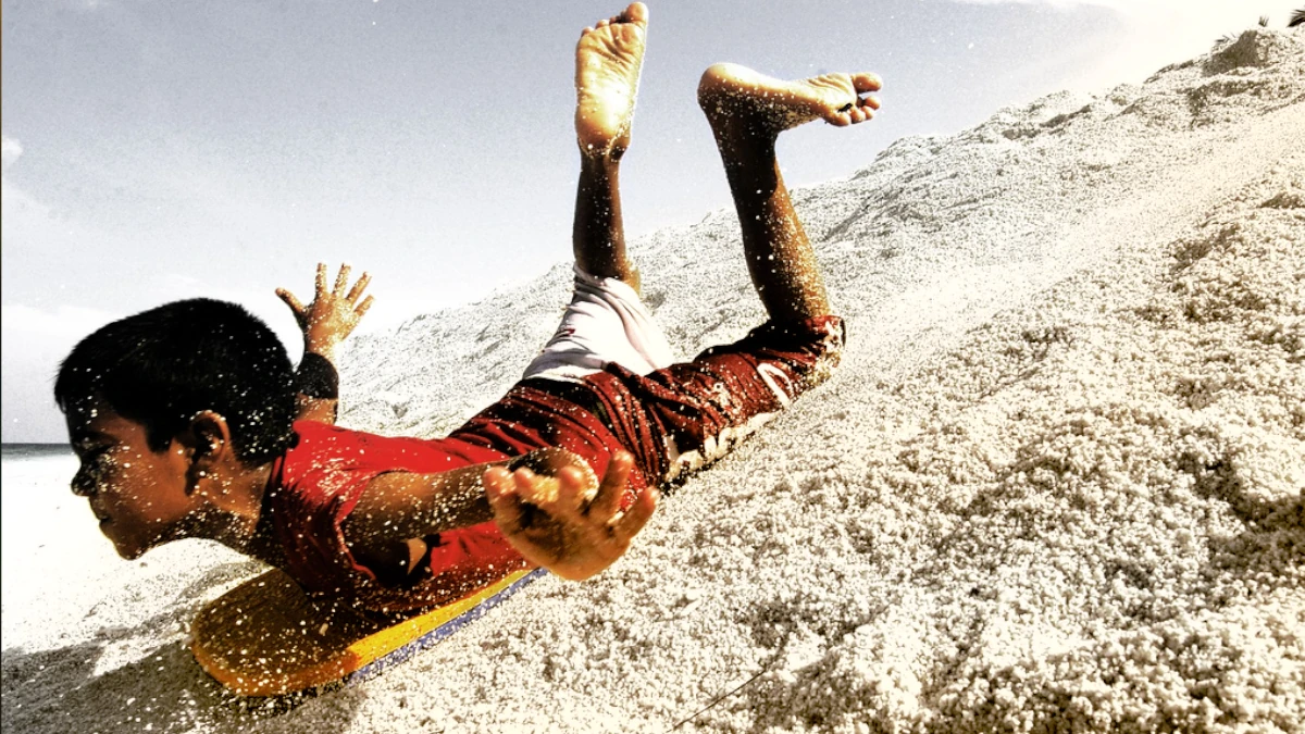 A boy sandboarding in Fuvahmulah, Maldives.