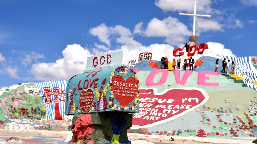 A colorful view of Salvation Mountain, adorned with biblical verses and vibrant murals.