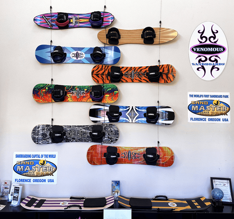 Handcrafted sandboards by Lon Beale on display at the Florence Area Chamber of Commerce exhibit, highlighting vibrant designs and intricate patterns.