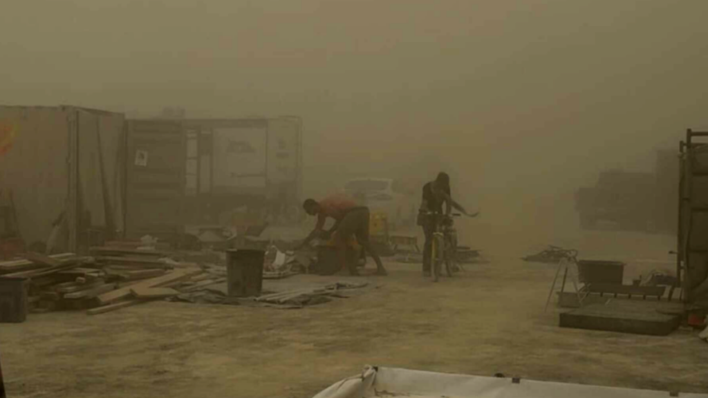 Burners endure harsh conditions as a powerful dust storm tears through Black Rock City, scattering debris and reducing visibility