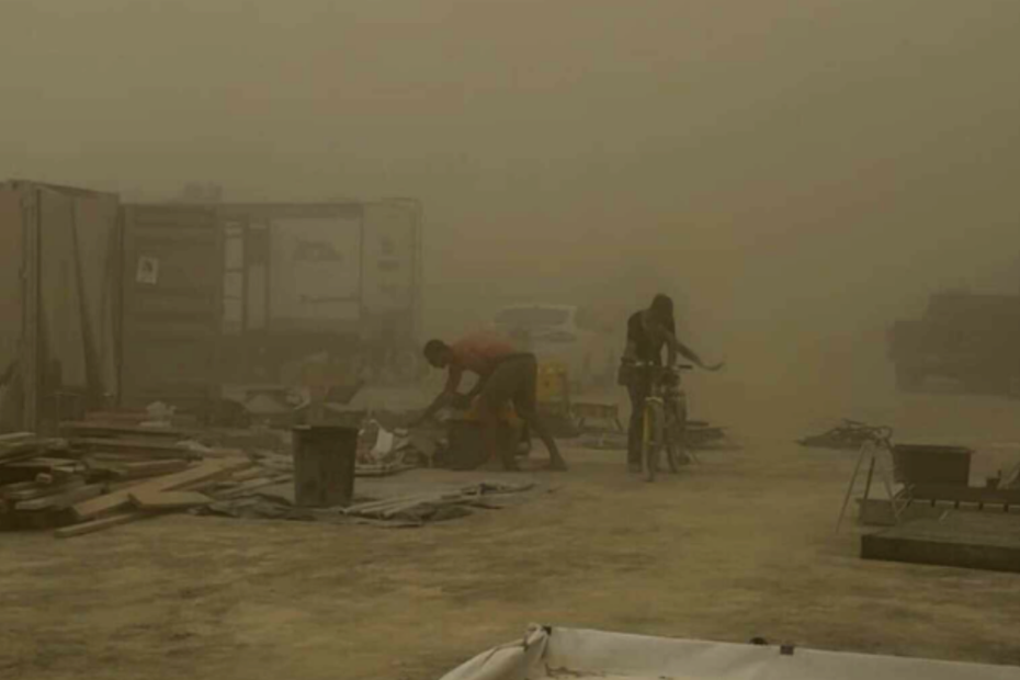 Burners endure harsh conditions as a powerful dust storm tears through Black Rock City, scattering debris and reducing visibility